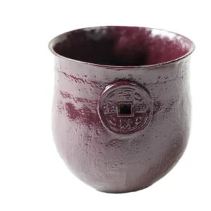 Full front shot of handmade floating red glaze ceramic mug inspired by The Moon and Sixpence, display single embossed coin anti-scald grip and open inner cavity