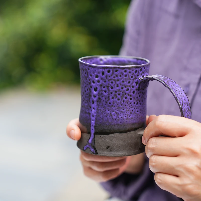 Lifestyle view of the handmade Heartbreak ceramic mug showing its expressive purple glaze and comfortable oversized handle